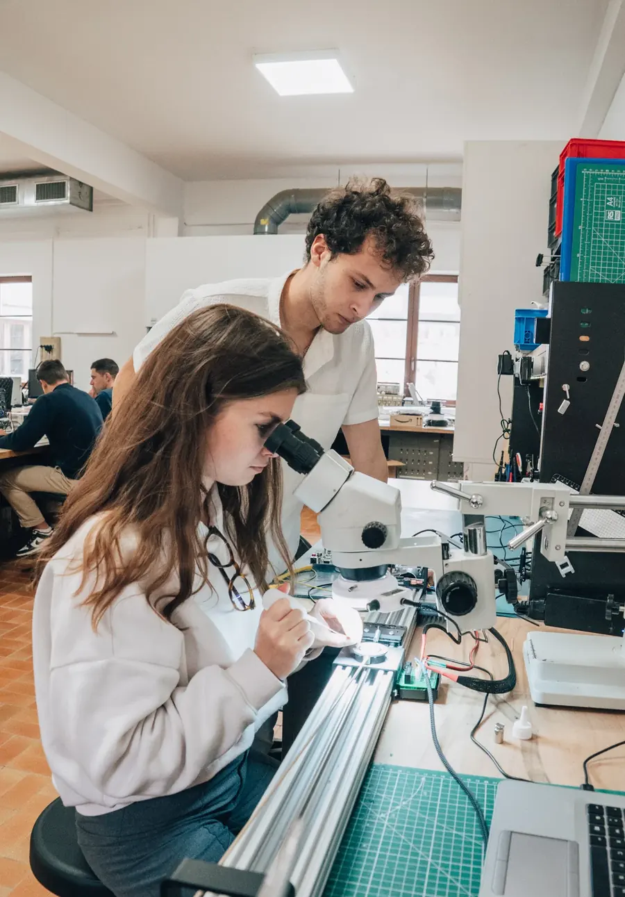 Une ingénieure observe une pièce au microscope